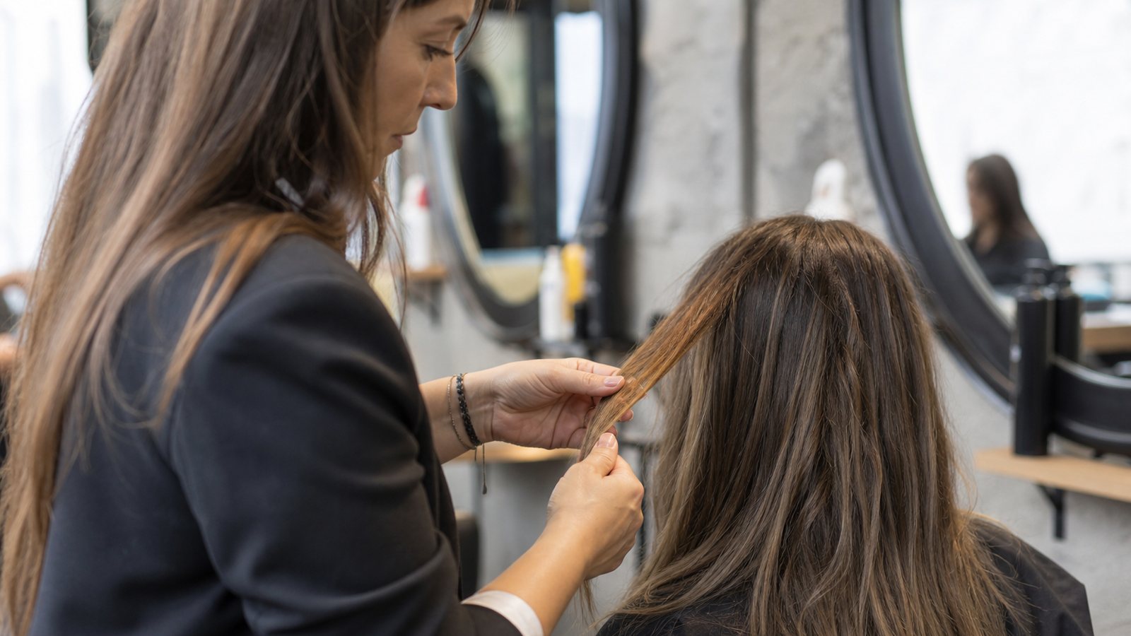 Coiffeuse examinant une mèche de cliente colorée à la maison avant la correction